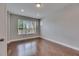 A bedroom with hardwood floors, neutral gray walls, and a large window with lots of natural light at 6611 Current Dr, Apollo Beach, FL 33572