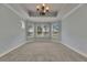 Carpeted bedroom featuring a trey ceiling and windows overlooking the property at 6611 Current Dr, Apollo Beach, FL 33572