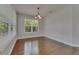 Bright dining room featuring hardwood floors, large windows, and a stylish chandelier at 6611 Current Dr, Apollo Beach, FL 33572