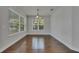 Bright dining room featuring hardwood floors, large windows, and a stylish chandelier at 6611 Current Dr, Apollo Beach, FL 33572