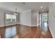 An empty dining area features hardwood floors, a modern chandelier, and an open design to the rest of the house at 6611 Current Dr, Apollo Beach, FL 33572