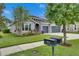 Charming single-story home featuring a stone accent entry, a two-car garage, and landscaped yard at 6611 Current Dr, Apollo Beach, FL 33572