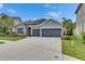 Charming single-story home featuring a stone accent entry, well-manicured lawn, and a two-car garage at 6611 Current Dr, Apollo Beach, FL 33572