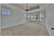 Serene bedroom with tray ceiling, carpeted floors, and lots of natural light from several windows at 6611 Current Dr, Apollo Beach, FL 33572
