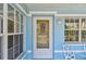 Close-up of the front door surrounded by windows, providing natural light and curb appeal at 711 6Th Ne St, Largo, FL 33770