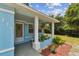 Inviting front porch with white columns and seating area, perfect for enjoying the outdoors at 711 6Th Ne St, Largo, FL 33770