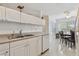 Practical kitchen layout featuring stainless steel sink, dishwasher, and a view towards the dining area at 711 6Th Ne St, Largo, FL 33770