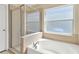 Clean bathroom features a glass-enclosed shower, soaking tub, and a large window at 7705 Dragon Fly Loop, Gibsonton, FL 33534