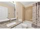Bright bathroom featuring a granite vanity, framed mirror and shower with tan tile surround at 7705 Dragon Fly Loop, Gibsonton, FL 33534
