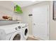 Well-lit laundry room featuring modern Samsung washer and dryer with shelving and white door at 7705 Dragon Fly Loop, Gibsonton, FL 33534