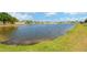 Beautiful pond with fountain, framed by a green grassy area in a residential neighborhood at 7705 Dragon Fly Loop, Gibsonton, FL 33534