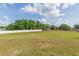 An expansive backyard with abundant green grass and a long white fence at 7939 Merchantville Cir, Zephyrhills, FL 33540