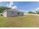 Landscaped backyard featuring a well-maintained lawn, lush trees, and perimeter fencing at 7939 Merchantville Cir, Zephyrhills, FL 33540