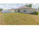 A spacious backyard with green grass, partial views of the home, and a white fence at 7939 Merchantville Cir, Zephyrhills, FL 33540