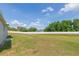 Large backyard with a well-maintained lawn and a long white fence at 7939 Merchantville Cir, Zephyrhills, FL 33540