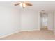 Spacious carpeted bedroom with a ceiling fan, offering a view into the bright, adjacent bathroom at 7939 Merchantville Cir, Zephyrhills, FL 33540