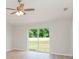 Bright bedroom featuring a ceiling fan, new flooring, and a sliding glass door with a view of the backyard at 7939 Merchantville Cir, Zephyrhills, FL 33540