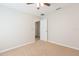 Bedroom showcasing a ceiling fan and an open doorway, enhanced by neutral walls and plush carpeting at 7939 Merchantville Cir, Zephyrhills, FL 33540