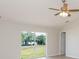 Bright bedroom featuring a ceiling fan, new flooring, and a sliding glass door with a view of the backyard at 7939 Merchantville Cir, Zephyrhills, FL 33540