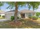 Charming single-story home with a two-car garage and a well-maintained lawn with mature shade trees at 7939 Merchantville Cir, Zephyrhills, FL 33540