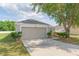 Charming single-story home with a two-car garage and a well-maintained lawn with mature shade trees at 7939 Merchantville Cir, Zephyrhills, FL 33540