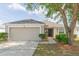 Charming single-story home with a two-car garage, a well-maintained lawn and a mature shade tree at 7939 Merchantville Cir, Zephyrhills, FL 33540