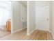 Hallway with new floors leads to bathroom featuring wood cabinets and a toilet at 7939 Merchantville Cir, Zephyrhills, FL 33540
