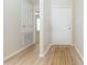 Hallway with new floors leads to the front door and an adjacent room, providing easy access throughout the home at 7939 Merchantville Cir, Zephyrhills, FL 33540
