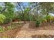 Landscaped backyard with brick pathway, gazebo, and mature trees, creating a serene outdoor retreat at 9395 Belvedere St, Spring Hill, FL 34608