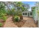Landscaped brick backyard with lounge chairs and access to the enclosed patio at 9395 Belvedere St, Spring Hill, FL 34608