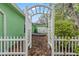 Charming backyard view through a white trellis, showcasing the yard's peaceful and private atmosphere at 9395 Belvedere St, Spring Hill, FL 34608