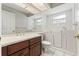Bright bathroom with dark wood vanity, granite countertop, and accessible tub at 9395 Belvedere St, Spring Hill, FL 34608