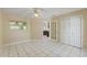 Bedroom featuring tiled floor, ceiling fan, window, and access to other rooms at 9395 Belvedere St, Spring Hill, FL 34608