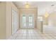Welcoming foyer with decorative glass double doors, high ceilings, tile flooring, and elegant chandeliers at 9395 Belvedere St, Spring Hill, FL 34608