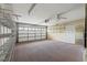 Spacious garage with white garage door, shelving, and fan, offering ample storage and functionality at 9395 Belvedere St, Spring Hill, FL 34608