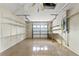 A clean, empty garage featuring shelving, a workbench, and a partially open door at 9395 Belvedere St, Spring Hill, FL 34608