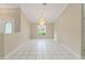 Bright living room featuring tile floors, a decorative chandelier, and large window for natural light at 9395 Belvedere St, Spring Hill, FL 34608