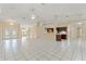 Open living space with neutral color palette, tile flooring, easy access to the front foyer and kitchen at 9395 Belvedere St, Spring Hill, FL 34608