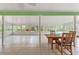 Spacious sunroom featuring tile flooring, a wooden table, dining chairs, and access to the outdoors at 9395 Belvedere St, Spring Hill, FL 34608