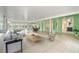 Bright sunroom with tile flooring, ceiling fans, large windows, seating area, dining table and hot tub at 9395 Belvedere St, Spring Hill, FL 34608