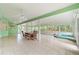 Large sunroom with tile flooring, dining table and chairs, hot tub, ceiling fans, and bright, natural light at 9395 Belvedere St, Spring Hill, FL 34608