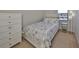 Comfortable bedroom with a white dresser and nautical themed bedding at 10100 Sailwinds N Blvd # 203, Largo, FL 33773