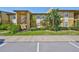 Charming exterior view of the tan condo featuring lush landscaping and ample parking at 10100 Sailwinds N Blvd # 203, Largo, FL 33773