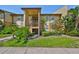 Inviting exterior view of the tan condo, showcasing well-maintained landscaping and building facade at 10100 Sailwinds N Blvd # 203, Largo, FL 33773