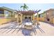 Inviting outdoor grilling area with pergola and multiple seating options at 10100 Sailwinds N Blvd # 203, Largo, FL 33773