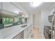 Open kitchen featuring white cabinetry and a breakfast bar overlooking the spacious living room at 10100 Sailwinds N Blvd # 203, Largo, FL 33773