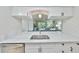 Bright kitchen with white cabinetry and sleek countertops, open to living area at 10100 Sailwinds N Blvd # 203, Largo, FL 33773