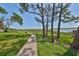 Scenic view of lakeside path with trees, green grass, and a tranquil lake view, perfect for walks at 10100 Sailwinds N Blvd # 203, Largo, FL 33773