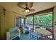 Comfortable screened lanai with ceiling fan, chairs, and table overlooking green landscape at 10100 Sailwinds N Blvd # 203, Largo, FL 33773