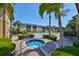 Community pool and spa surrounded by lush tropical landscaping and lounge chairs at 10100 Sailwinds N Blvd # 203, Largo, FL 33773